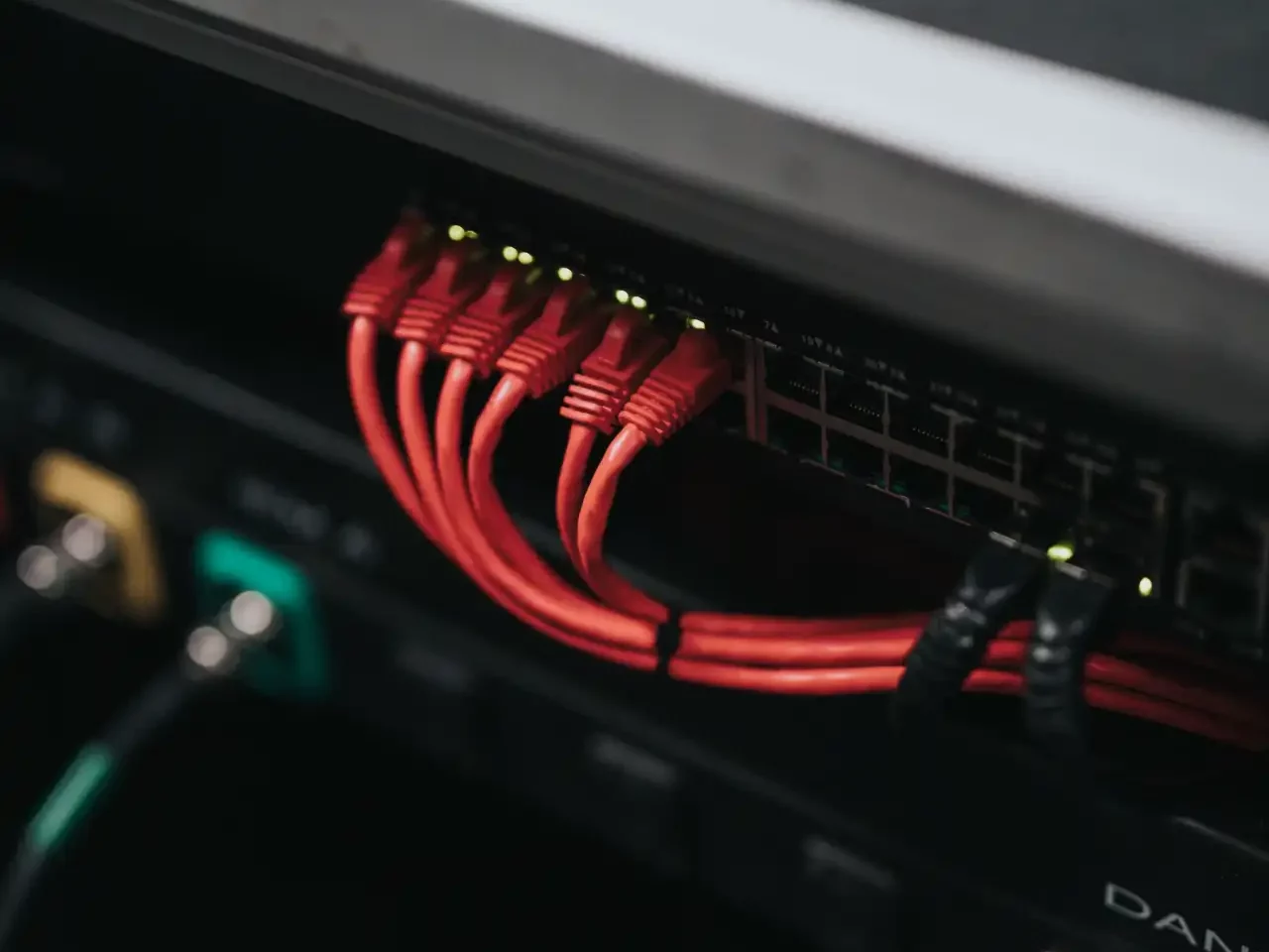Rote Netzwerkkabel mit Kabelführung und Kabelbindern angeschlossen an einem Netzwerkswitch