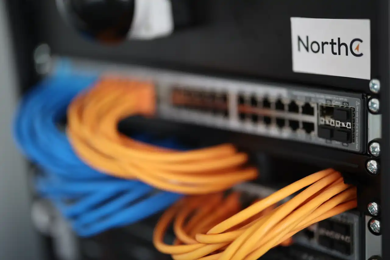 NorthC Netzwerkswitch mit farbiger und geordneter Netzwerkverkabelung mit Patchkabel